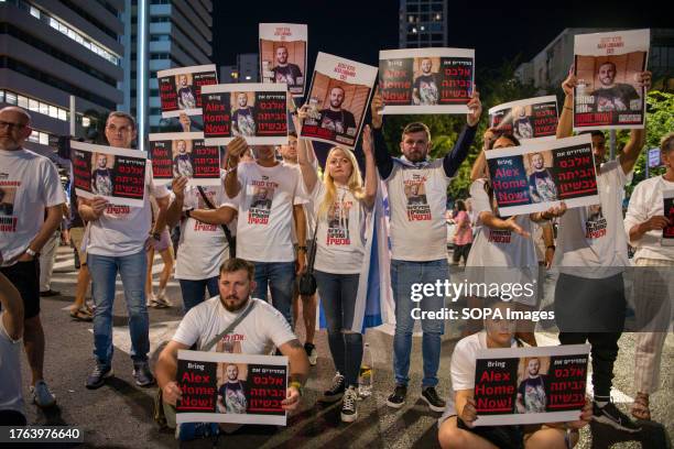 Relatives and friends of Alex Lobanov, kidnapped by Hamas on October 7, carry portraits during the demonstration in the city of Tel Aviv. The...