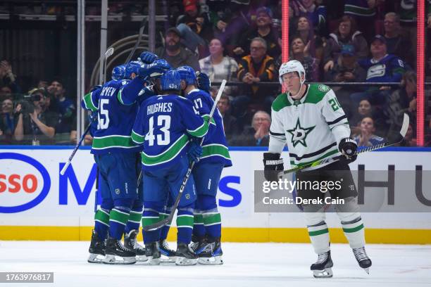 Vancouver Canucks players celebrate after a goal as Ryan Suter of the Dallas Stars skates on during the second period of their NHL game at Rogers...