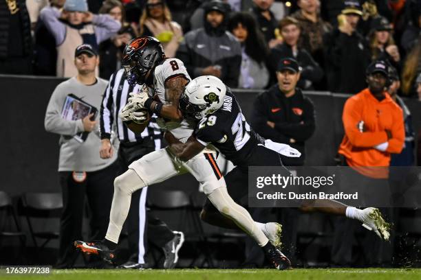 Rweha Munyagi Jr. #8 of the Oregon State Beavers is tackled by Rodrick Ward of the Colorado Buffaloes after a catch and first down in the third...