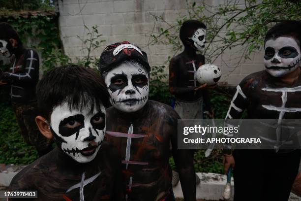 Children show their painted bodies and faces during the traditional Calabiuza Festival in Tonacatepeque, on November 04, 2023 in San Salvador, El...