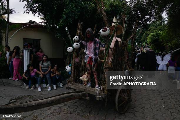 People watch a young woman traveling in a haunted wagon during the traditional Calabiuza Festival in Tonacatepeque, on November 04, 2023 in San...