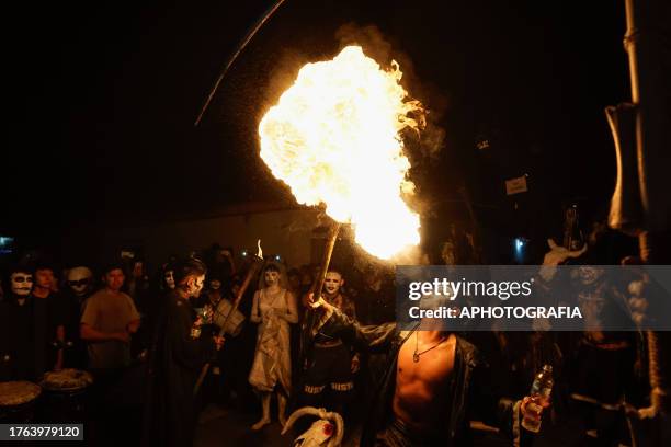 Young man spits gas into a torch fire during the traditional Calabiuza Festival in Tonacatepeque, on November 04, 2023 in San Salvador, El Salvador....