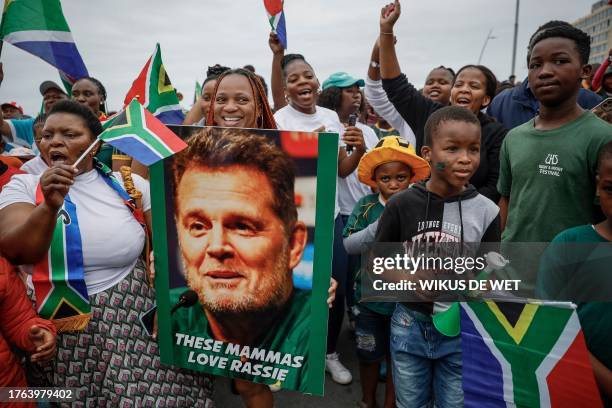 Supporters hold a picture of South African director of rugby Rassie Erasmus as they gather during the Springboks Champions trophy tour in East...
