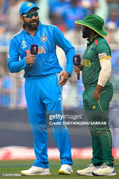 India's captain Rohit Sharma speaks with his South Africa counterpart Temba Bavuma after the toss before the start of the 2023 ICC Men's Cricket...