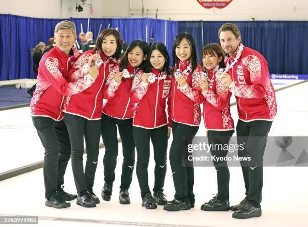 Members of Japan women's curling team Loco Solare pose for photos after winning silver at Pan Continental championships in Kelowna, Canada, on Nov....