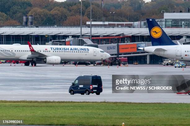 Police van observe the car of a hostage taker seen parked under a Turkish airline plane on the tarmac at the airport in Hamburg, northern Germany on...