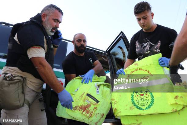 Comrades of four paramedics of the Lebanese Amal Movement civil defence teams, wounded after their ambulances were hit in a strike in the town of...