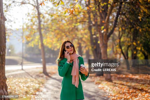 a woman walking in a park - lerexis stockfoto's en -beelden