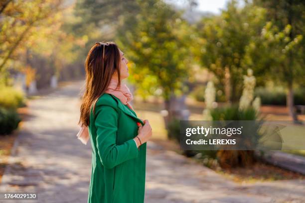 young woman in city park in autumn - lerexis stockfoto's en -beelden