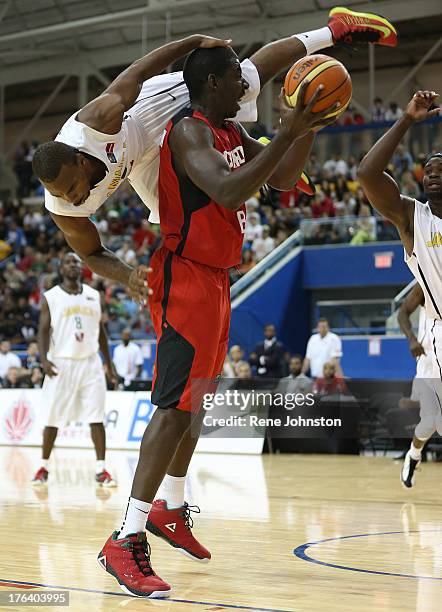 Team Canada Andrew Nicholson carries Team Jamaica guard Akeem Scott as the Jamaican player jumped over the Canadian in second half action at the...