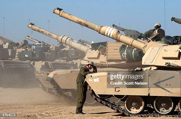 Army M1/A1 Abrahams 1-64 tank crew member leans against the front of his tank during a lull in a live fire training session February 6, 2003 on the...