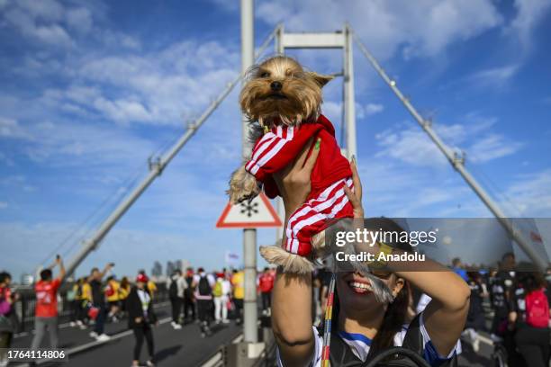 Woman carries a dog during the 45th Istanbul Marathon, the world's only intercontinental race, at 15 July Martyrs Bridge in Istanbul, Turkiye on...