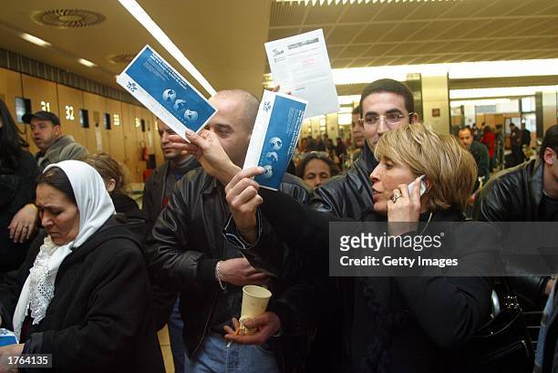An Air Lib employee directs stranded passengers February 6, 2003 at Orly airport in France. Air Lib, France's second largest carrier, grounded its...