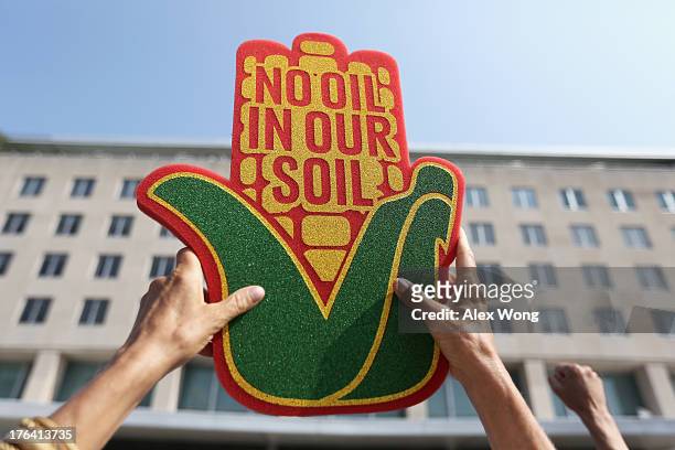 An activist holds up a sign during a sit-in and protest against the Keystone XL pipeline outside the U.S. State Department August 12, 2013 in...
