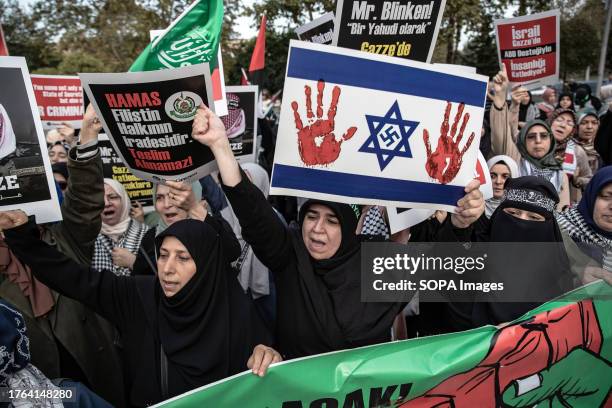 Demonstrator holding a representative Israeli flag depicting a swastika and a bloody hand chanted slogans in support of Palestine during the...