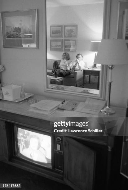 View of American attorney F. Lee Bailey and his wife Lynda Hart, both reflected in the mirror, as they watch television in their room at the Stanford...