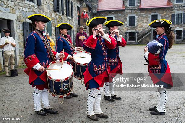 Marching band at Fort Ticonderoga dressed as French soldiers from 1755 plays a striking the colors tune for lowering the flag August 1, 2013 in...