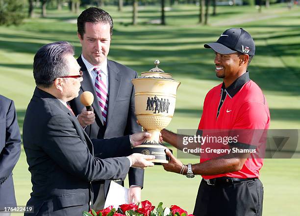 Bridgestone Global CEO and Chairman of the Board Masaaki Tsuya poses with Tiger Woods and the Gary Player Cup Trophy during the Final Round of the...
