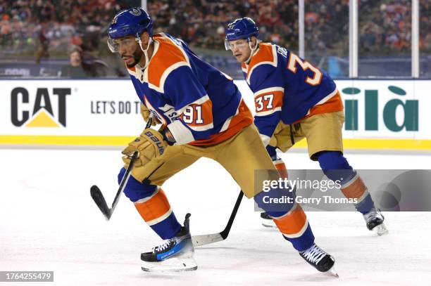 Evander Kane and Warren Foegele of the Edmonton Oilers skate during the third period of the 2023 Tim Hortons NHL Heritage Classic between the Calgary...