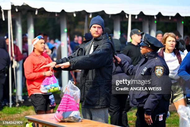 Officers searches a runner ahead of the 52nd Edition of the New York City Marathon on November 5, 2023.