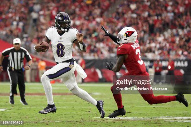 Uarterback Lamar Jackson of the Baltimore Ravens runs with the football past safety Budda Baker of the Arizona Cardinals during the NFL game at State...