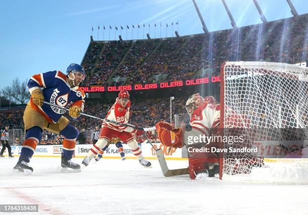 Connor McDavid of the Edmonton Oilers puts his shot wide of goal as goaltender Jacob Markstrom of the Calgary Flames defends his net during the first...