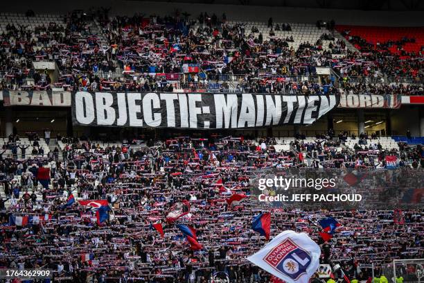 Lyon's supporters hold banners prior to the French L1 football match between Olympique Lyonnais and FC Metz at The Groupama Stadium in...