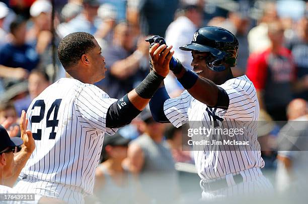 Alfonso Soriano of the New York Yankees celebrates his fourth inning home run against the Detroit Tigers with teammate Robinson Cano at Yankee...