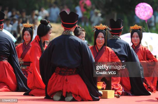 Couples of newlyweds wearing Han Chinese clothes attend the group wedding ceremony to greet the Chinese Valentine's Day at Pujiu Temple on August 13,...
