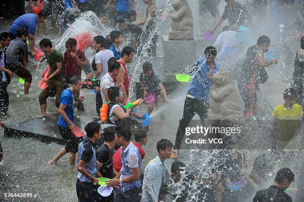 Visitors splash water on each other during the 2013 Hainan Qixian Hot-spring Water Festival to greet the Chinese Valentine's Day at Qixian Square on...