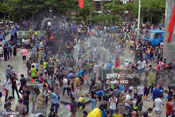 Visitors splash water on each other during the 2013 Hainan Qixian Hot-spring Water Festival to greet the Chinese Valentine's Day at Qixian Square on...