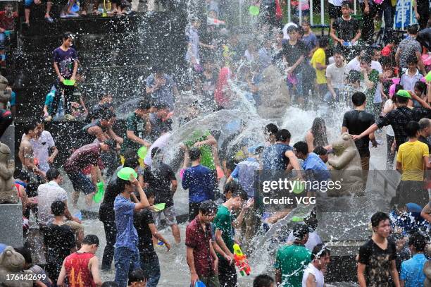 Visitors splash water on each other during the 2013 Hainan Qixian Hot-spring Water Festival to greet the Chinese Valentine's Day at Qixian Square on...