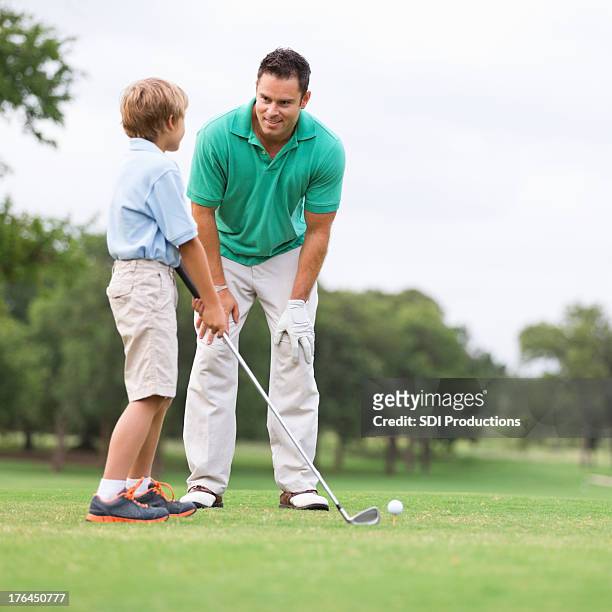father teaching his young son to golf - father son golf stock pictures, royalty-free photos & images