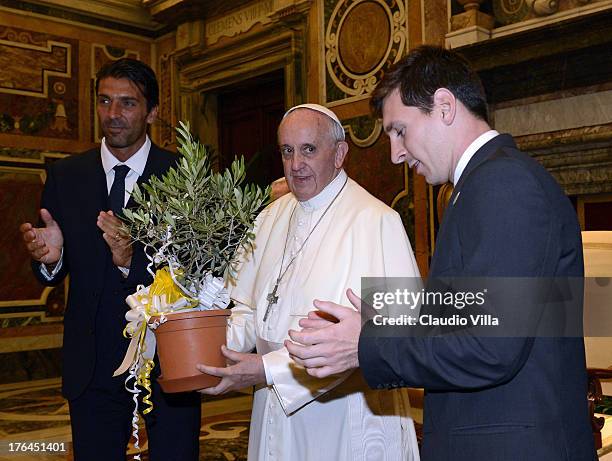 Pope Francis exchanges gifts with Gianluigi Buffon of Italy and Lionel Messi of Argentina during a private audience at The Vatican on August 13, 2013...