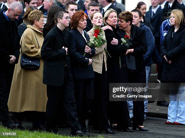 Friends and family members walk behind the flag-draped body of slain Ulster Defense Association Commander John Gregg February 6, 2003 in Belfast,...