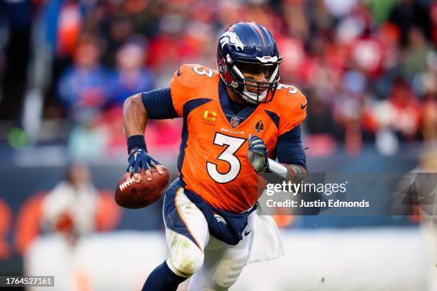 Quarterback Russell Wilson of the Denver Broncos scrambles out of the pocket and looks to pass during the fourth quarter against the Kansas City...