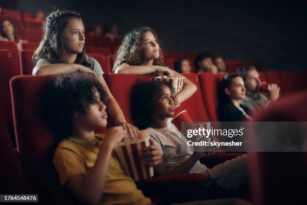 little friends watching a cartoon in cinema. - girls boys opening night stock pictures, royalty-free photos & images