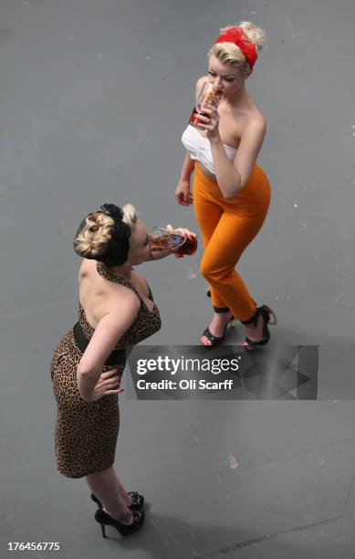 Two women pose as they drink real ale at the Great British Beer Festival in the Olympia exhibition centre on August 13, 2013 in London, England. The...