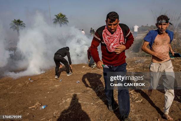 Protestors run amid the tear gas fired by Turkish anti-riot police during a Pro-Palestinian demonstration against US secretary of state's visit to...