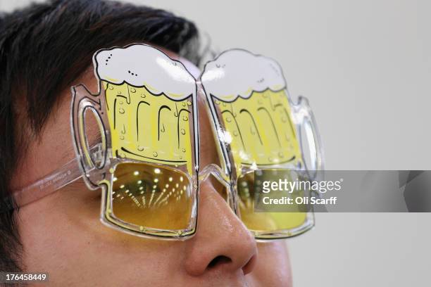 Phai Dip wears novelty, beer-related glasses at the Great British Beer Festival in the Olympia exhibition centre on August 13, 2013 in London,...