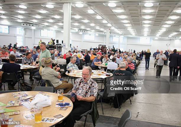 Drinkers consult the festival programme at the Great British Beer Festival in the Olympia exhibition centre on August 13, 2013 in London, England....