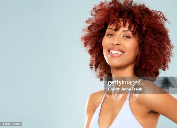 joyful expression: woman radiates happiness against a striking blue backdrop - pierced stock pictures, royalty-free photos & images