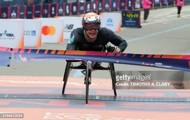 Marcel Hug of Switzerland crosses the finish line to win the Men's Pro Wheelchair Division at the 2023 New York City Marathon in New York on November...