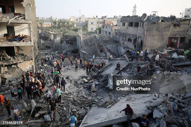 Palestinians search through the rubble of a collapsed building searching for survivors and victims following the Israeli bombardment of Al-Maghazi,...