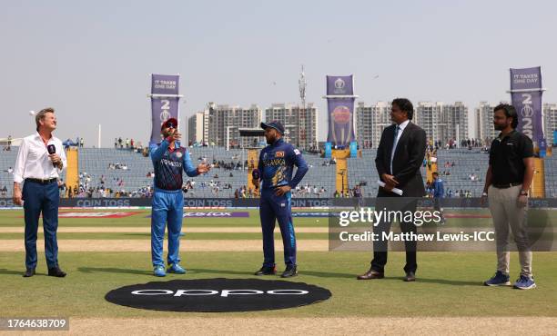 Hashmatullah Shahidi of Afghanistan flips the coin as Kusal Mendis of Sri Lanka looks on ahead of the ICC Men's Cricket World Cup India 2023 between...