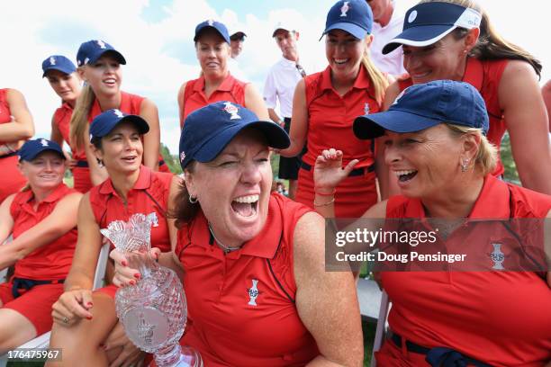 United States Solheim Cup Team Captain Meg Mallon holds the cup and shares a lighter moment with assistant captain Dottie Pepper and the other...