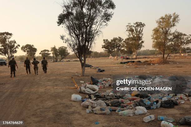 Israeli soldiers walk in a field on November 5 nearly a month after an attack on the Supernova music Festival by Hamas militants, near Kibbutz Reim...