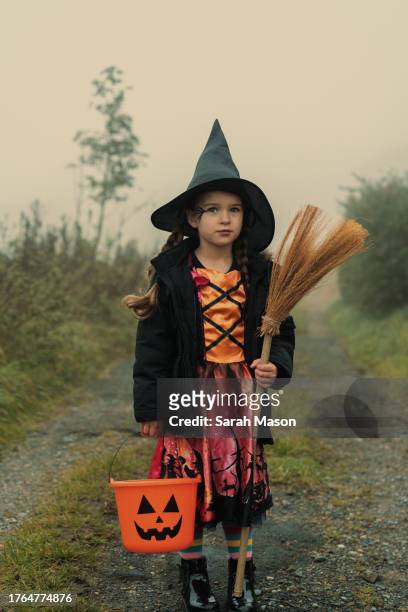 portrait of little girl in witch costume ready for trick or treating - sarah green stock pictures, royalty-free photos & images