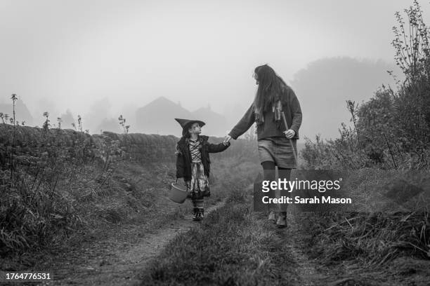 mother & daughter walking along lane holding hands - cleaning equipment stock pictures, royalty-free photos & images