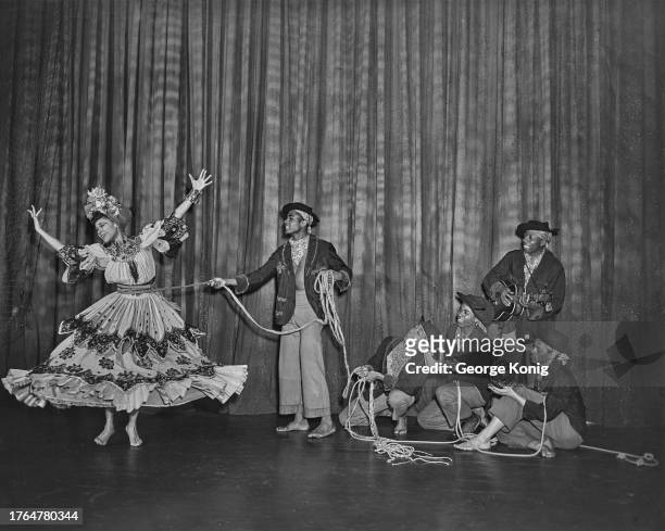 Group of male dancers hold choreographer Katherine Dunham by a rope tied around her waist during a performance of 'A Caribbean Rhapsody' at the...